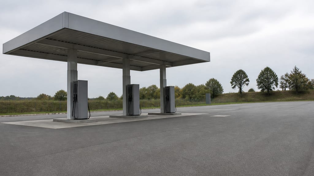 Illustration Station discount de grande surface, parking vide et auvent métallique en France — ambiance station-service type Carrefour — Rue Denis Papin ZA Louveterie à Bonneval, en grande surface (photo éditoriale, non contractuelle)