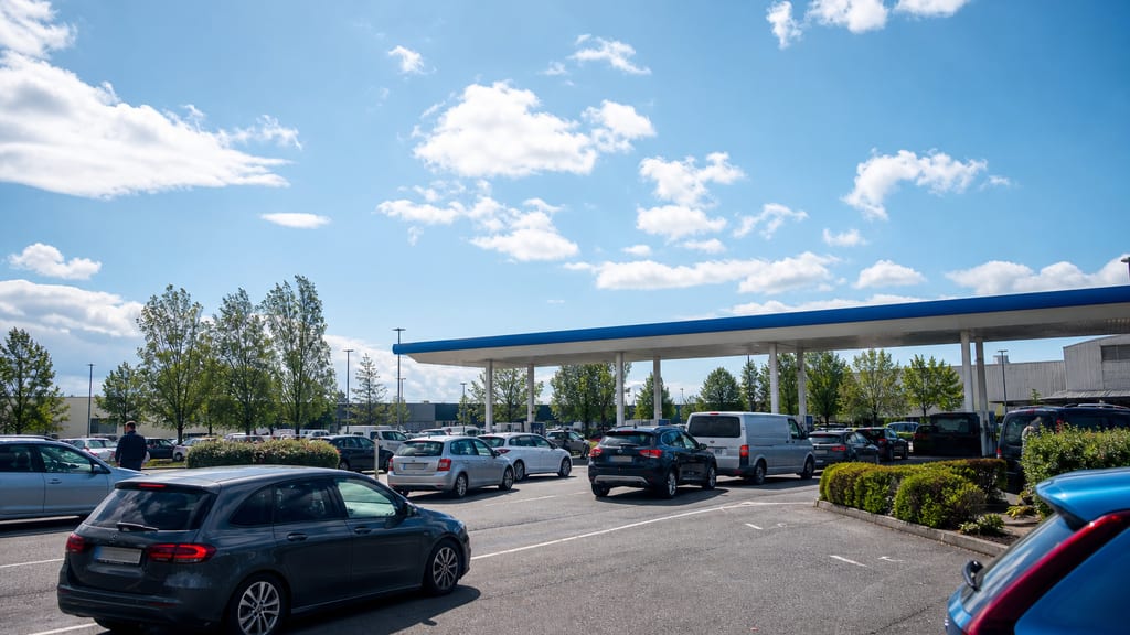 Illustration File discrète à une station d’hypermarché le week-end en France, auvent et parking — ambiance station-service type Intermarché — Avenue Général Leclerc à Jarnac, en grande surface (photo éditoriale, non contractuelle)